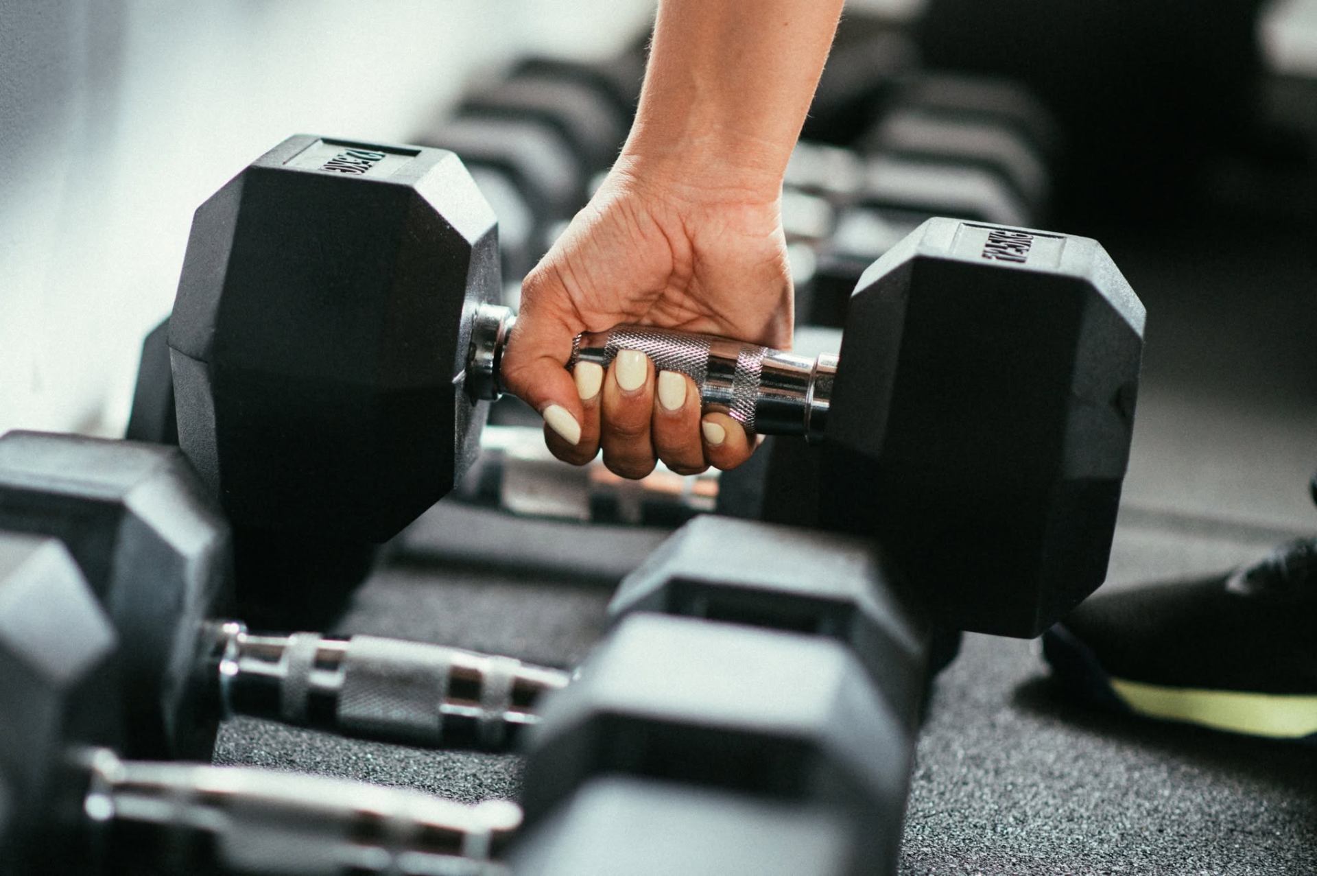 Athlete training with heavy weights in dark gym lit with shocking pink